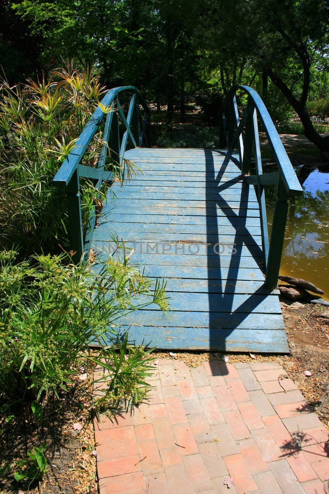 Old wood bridge built over small river.
