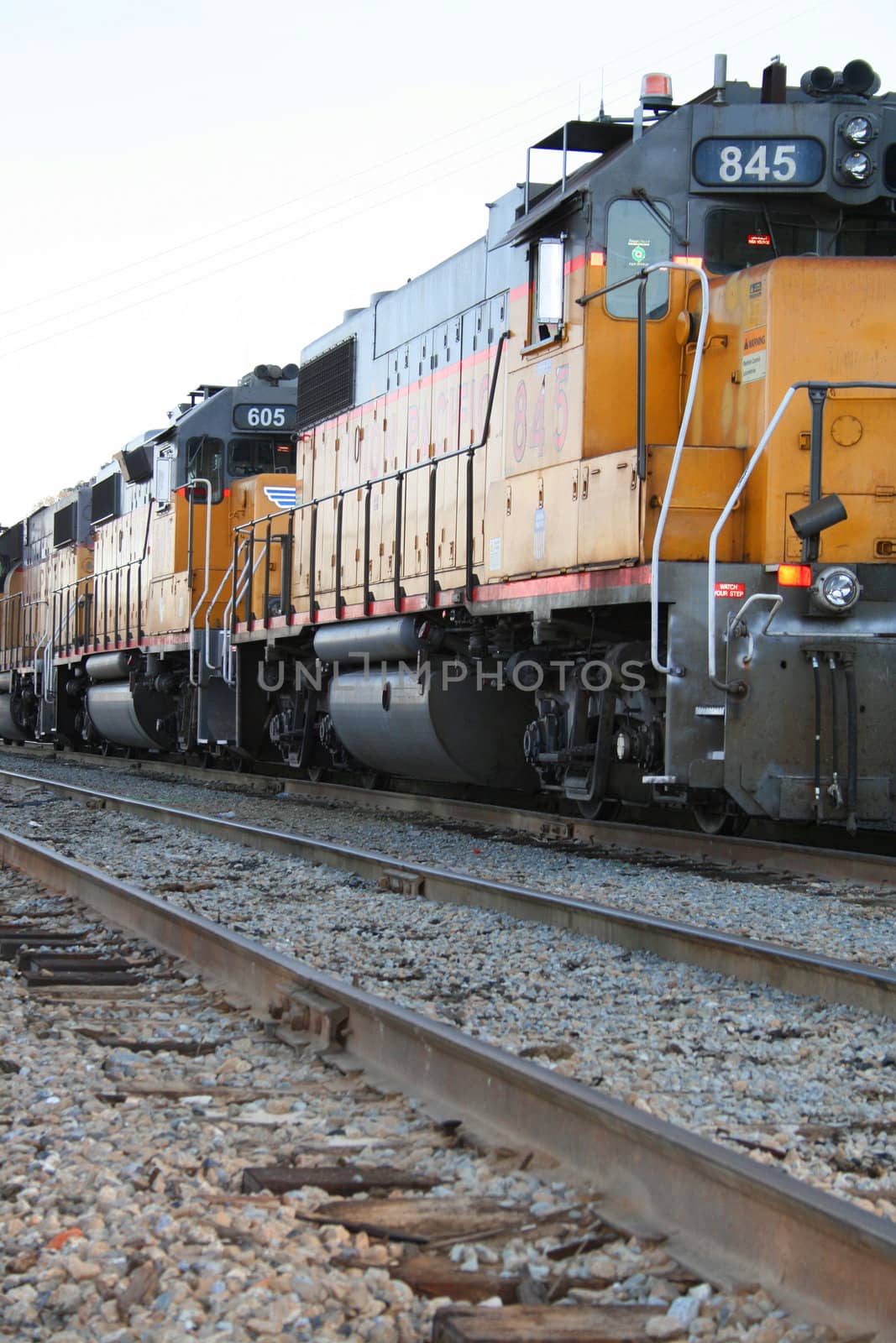 Yellow freight train parked at a train yard.
