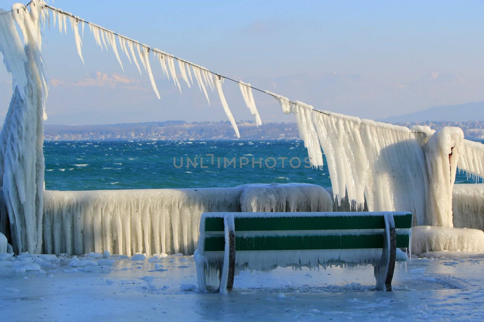 Frozen bench because of cold winter temperature and waves at Nyon, Switzerland
