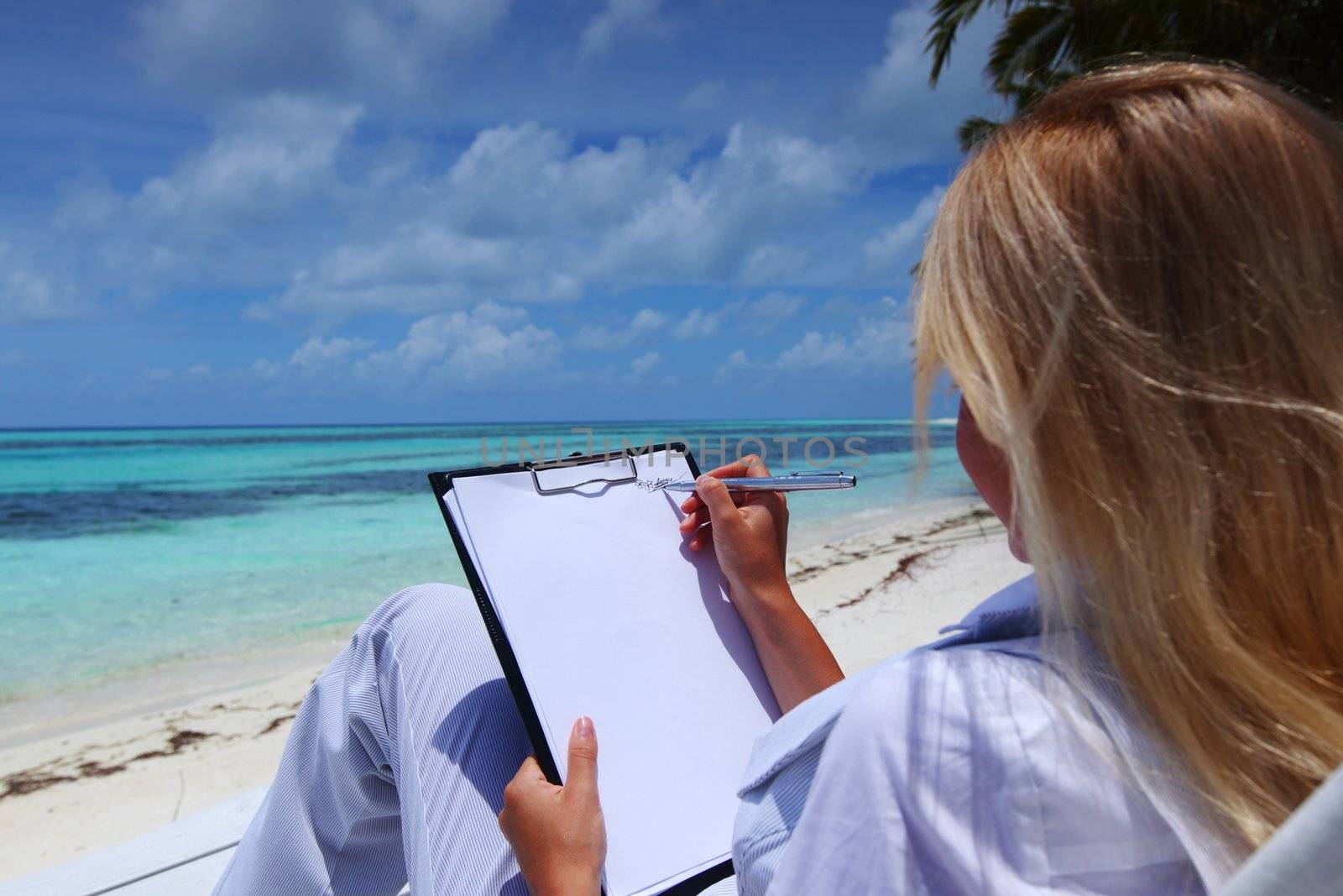 business woman with blank paper lying on a chaise lounge in the tropical ocean coast