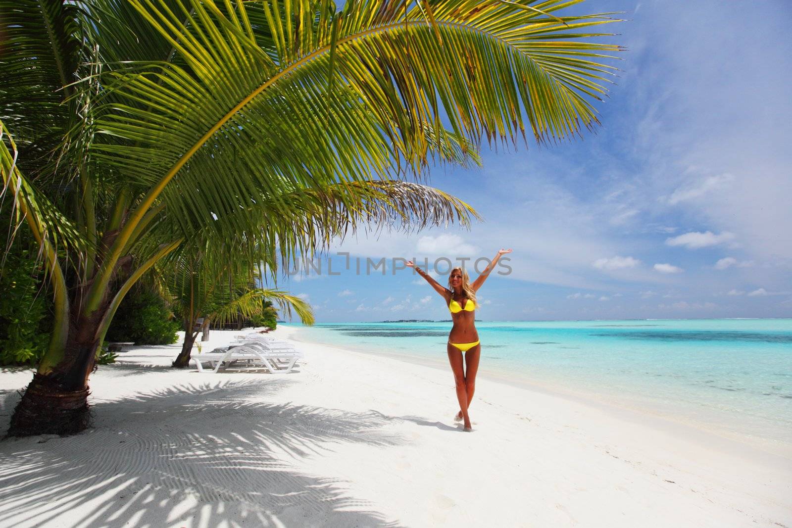 woman in bikini under palm on sea background