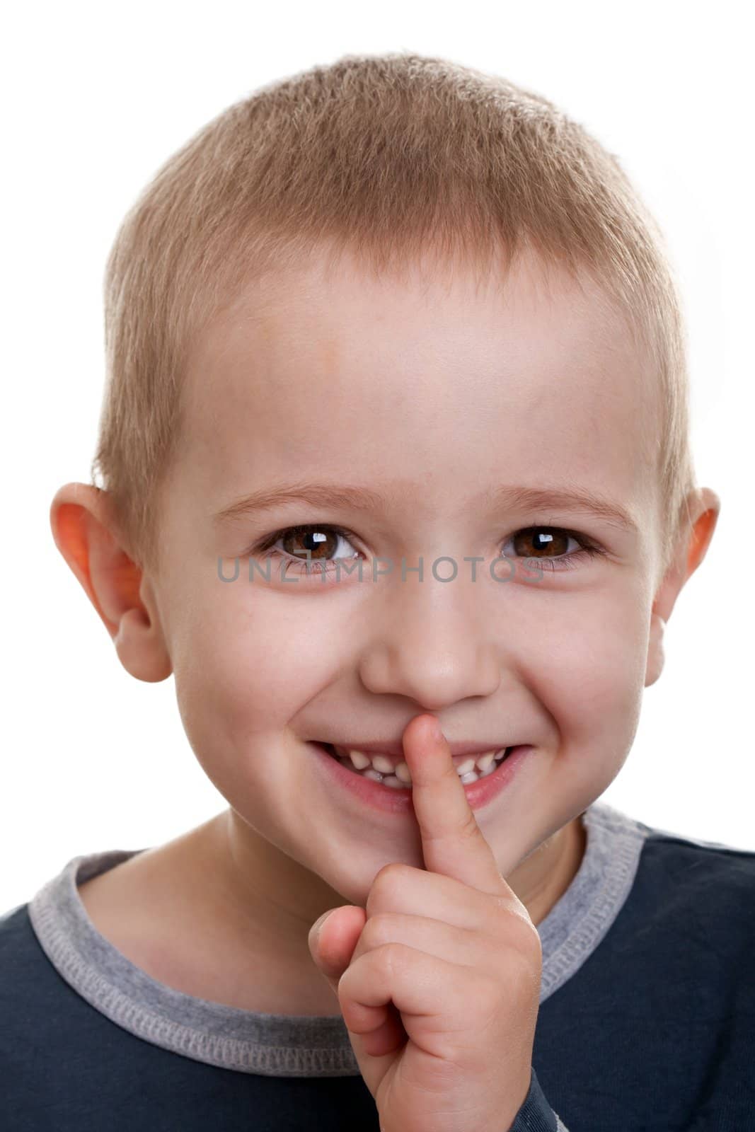 Human child face gesturing finger on lips silence