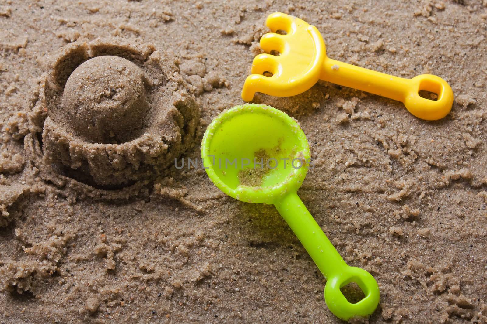 Plastic sandbox child toy on summer beach sand