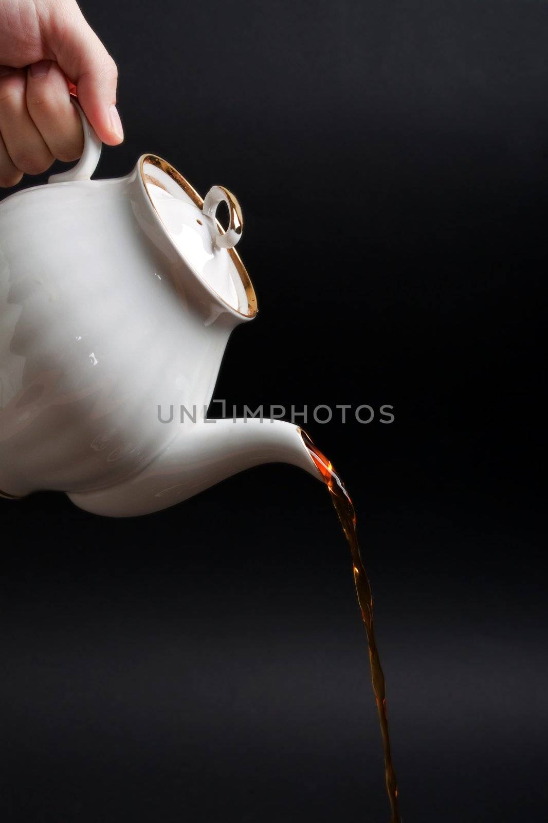 Afternoon drink - pouring heat tea cup from teapot