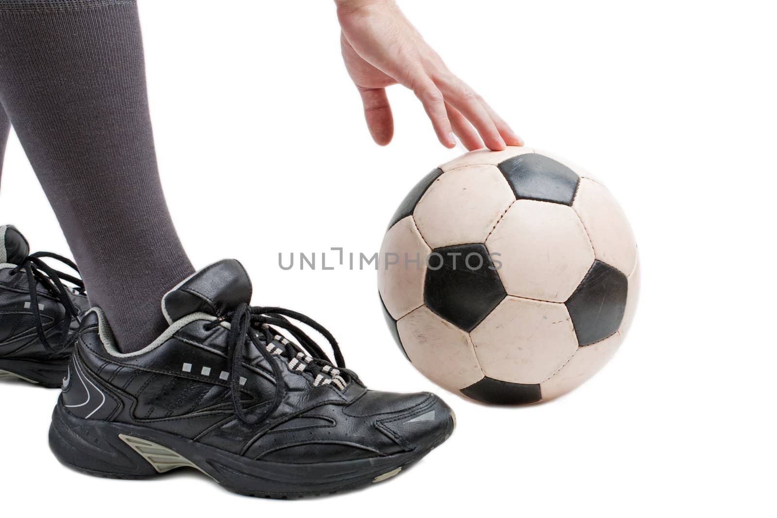 Foot on black white football or soccer sport ball