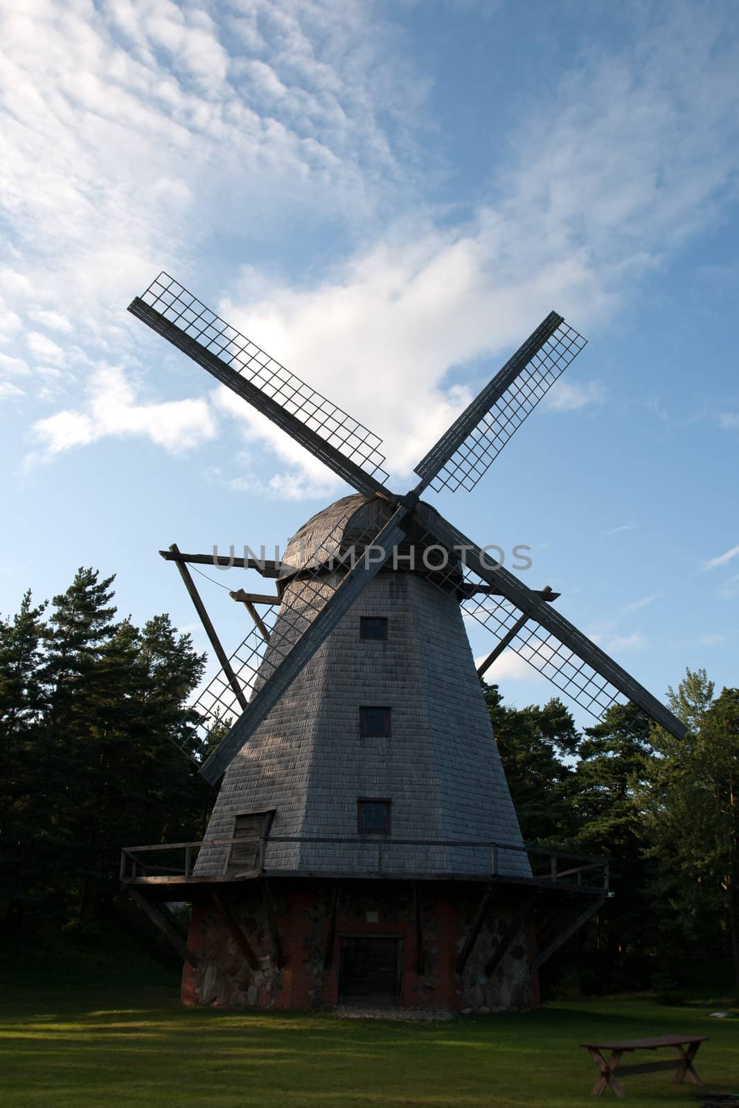 An old traditional windmill with wooden sails in countryside