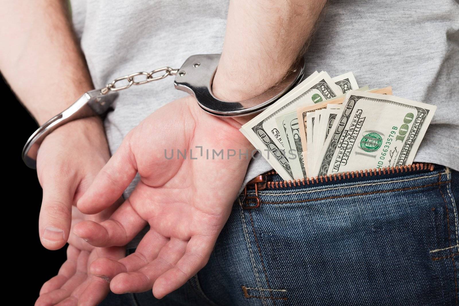 Handcuffs on hands hiding money by ia_64