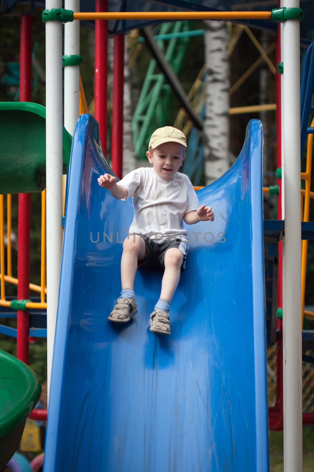 Little child fun playing playground slide outdoor