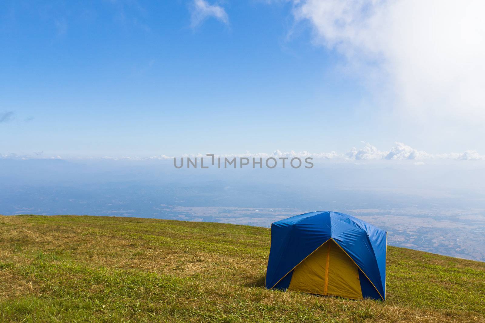 Tent on a grass under  blue sky by stoonn