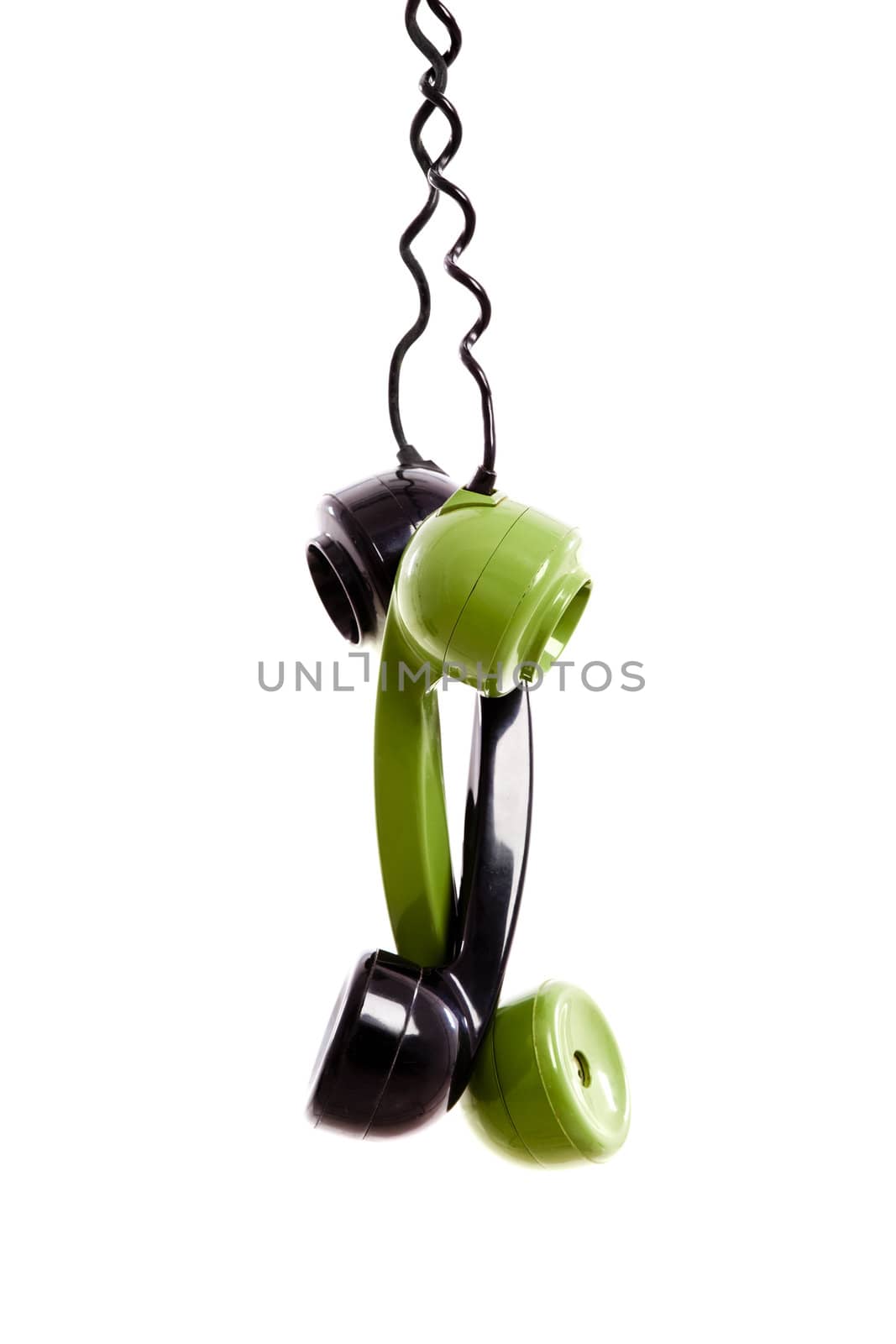 Two Handset piece from old phones suspended by the phone cord, isolated on white background