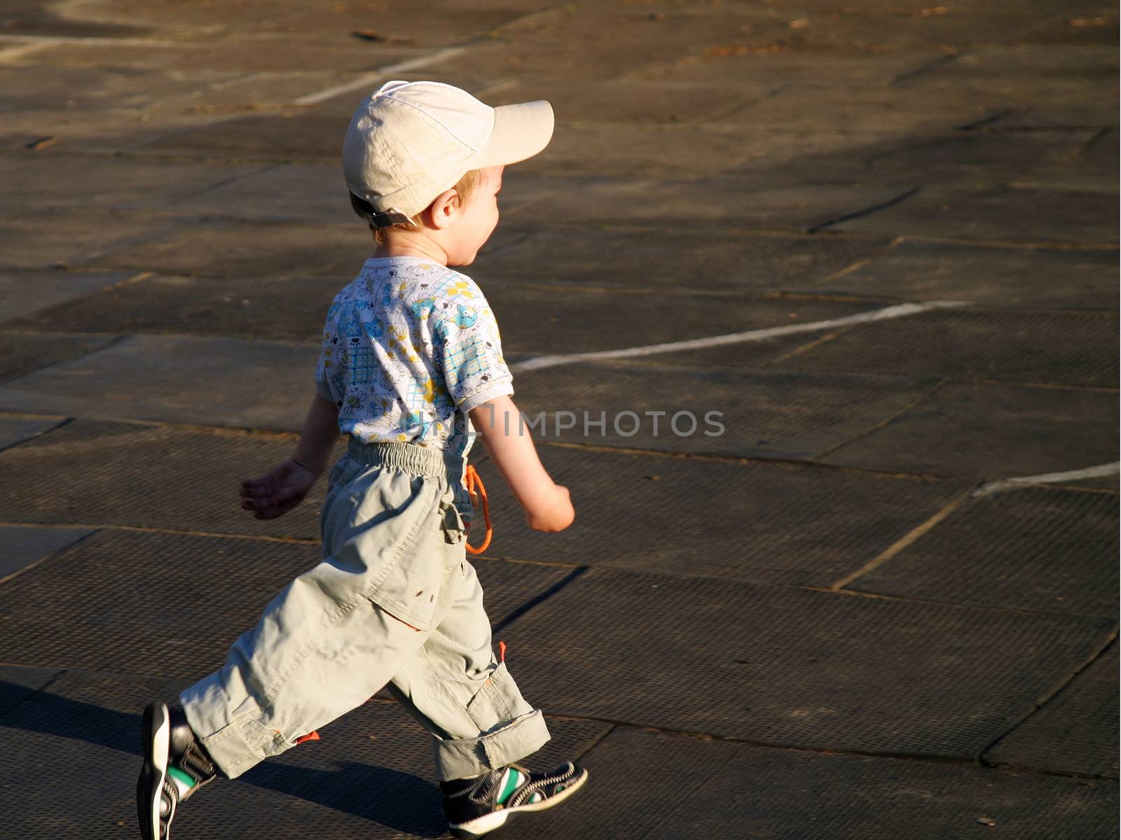 Little child playing soccer ball outdoors