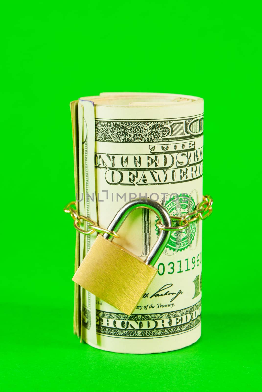 Roll of US dollars chained and locked over green background