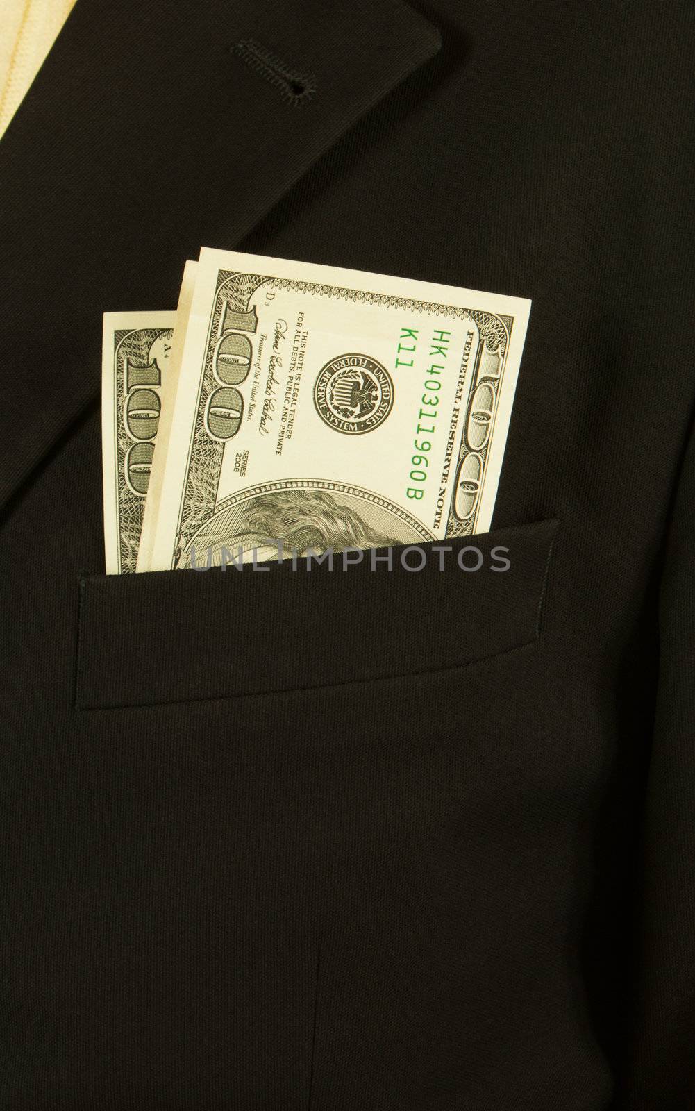 Close-up of businessman with dollar banknotes in suit pocket