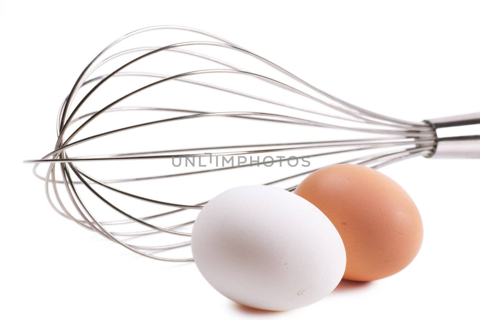 Whisk and two eggs over white background