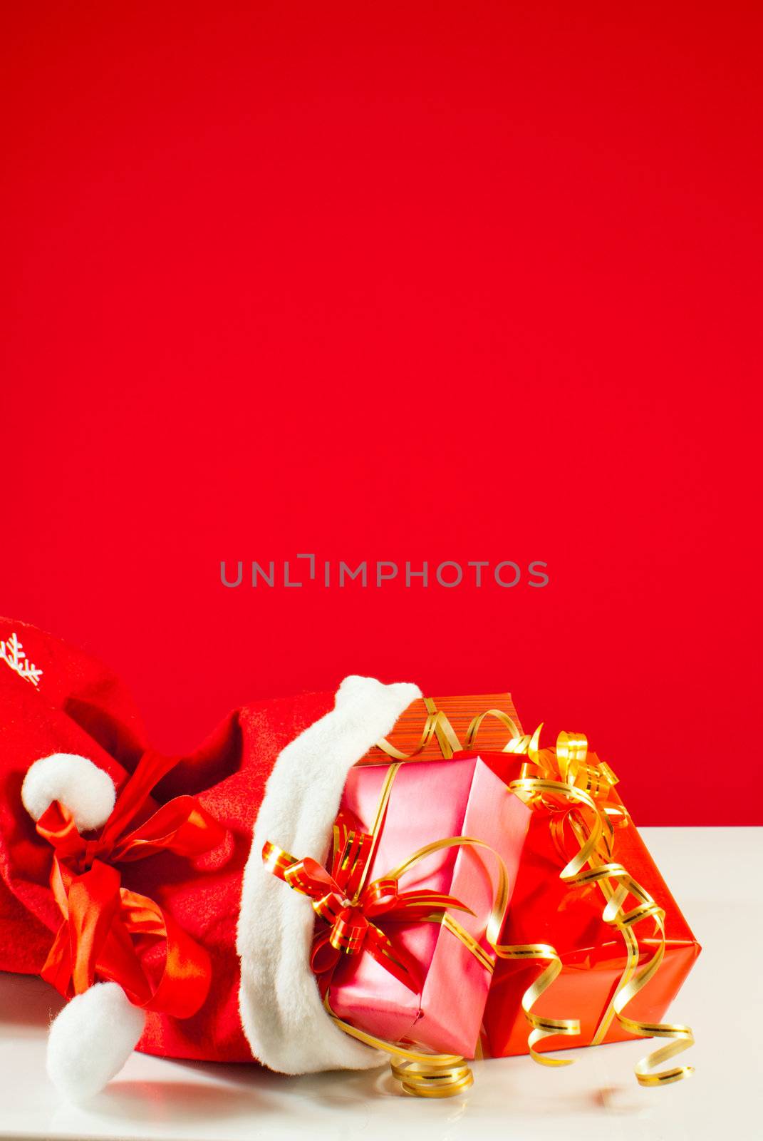 Christmas presents in the bag against red background