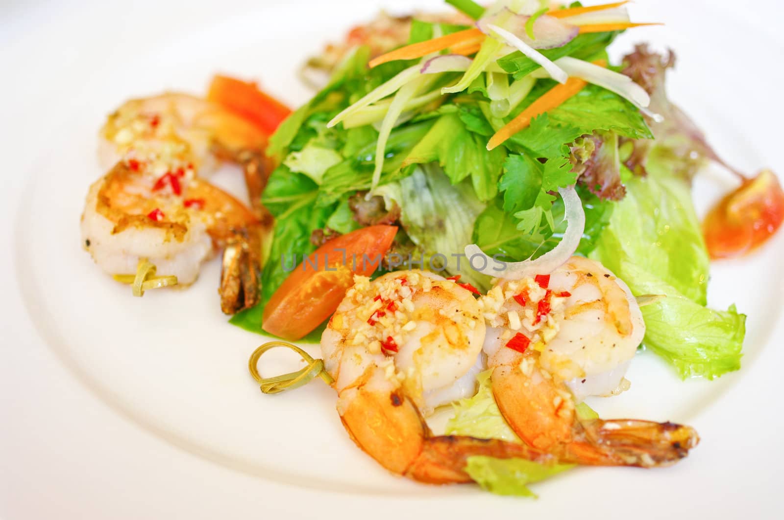 Shrimp with salad in white dish