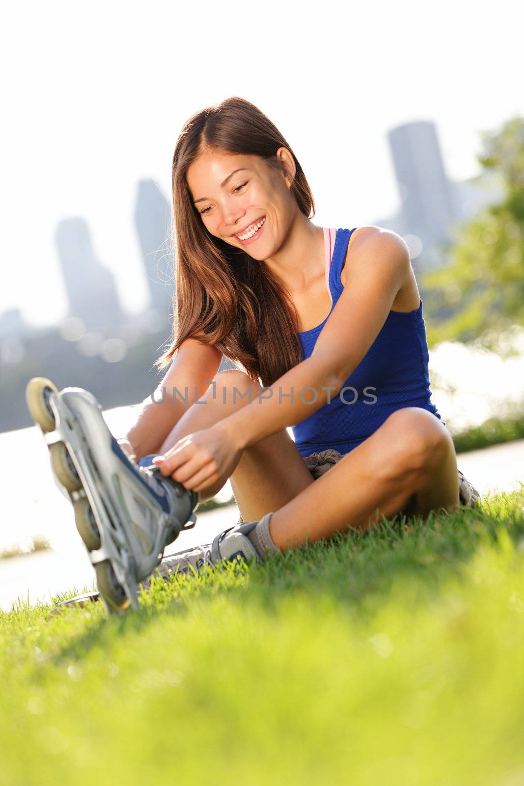 Rollerblades / roller skating woman going skating on inline roller blades. Young happy multiracial girl enjoying outdoor workout with Montreal city skyline in background.