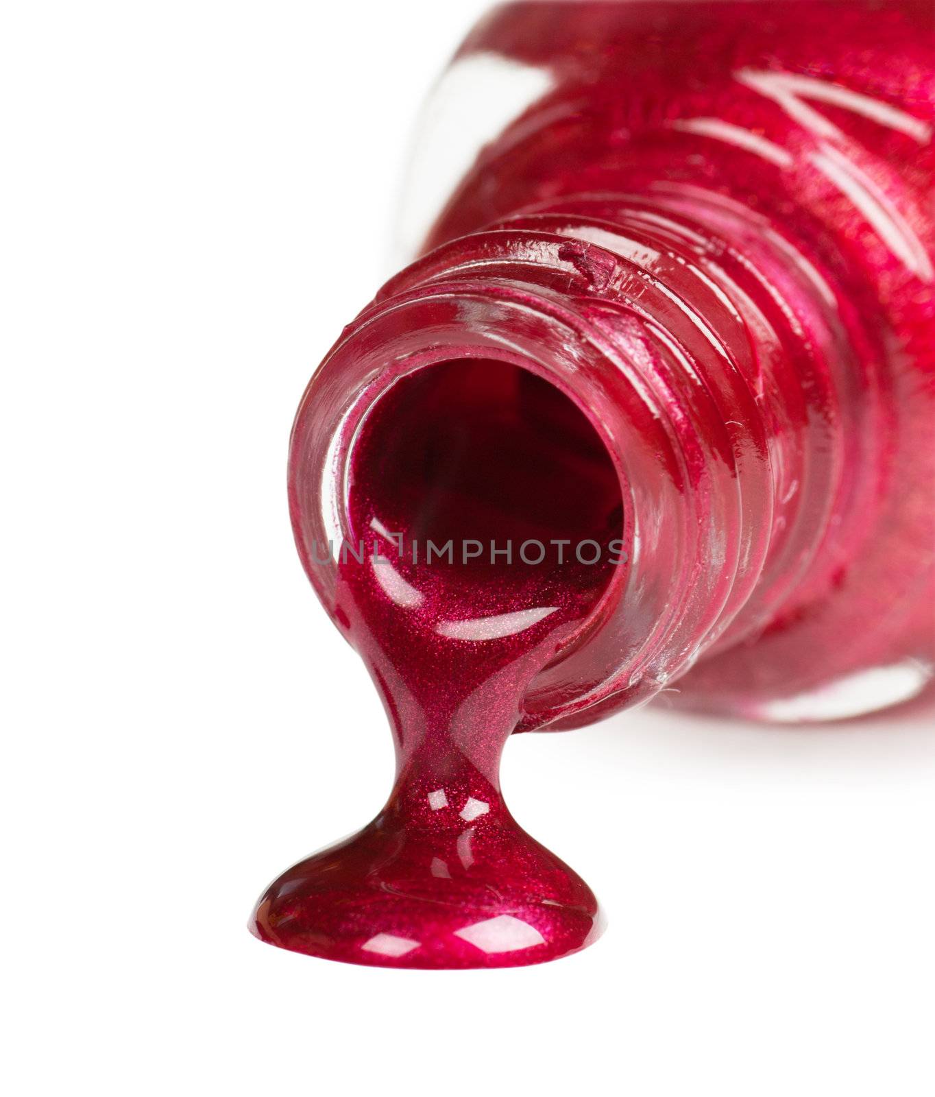 Red nail polish bottle spilled on a white background