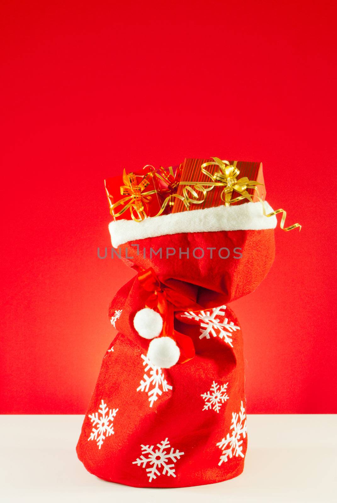 Christmas presents in the bag against red background