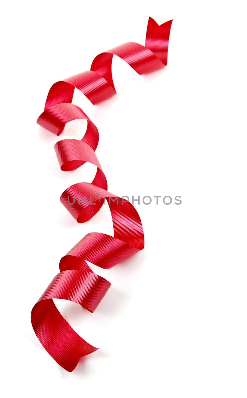 Curled red holiday ribbon strip isolated on white background