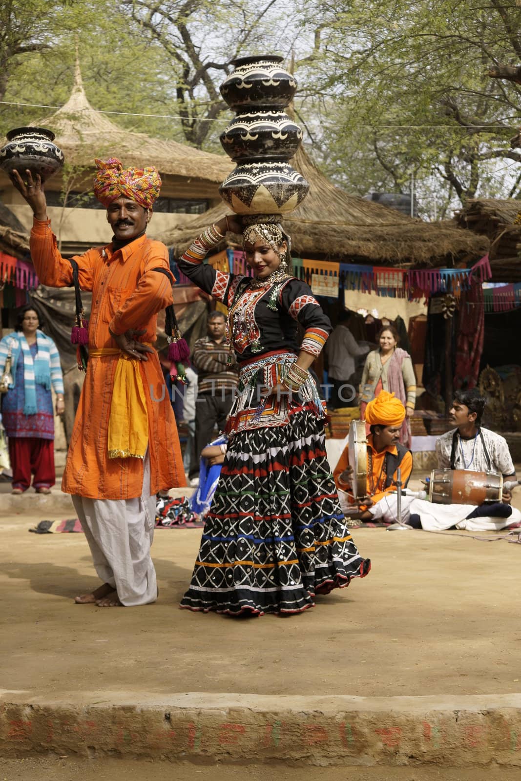 Female tribal dancer performing a dance involving balancing an increasing number of pots on her head at the annual Sarujkund Fair near Delhi, India.