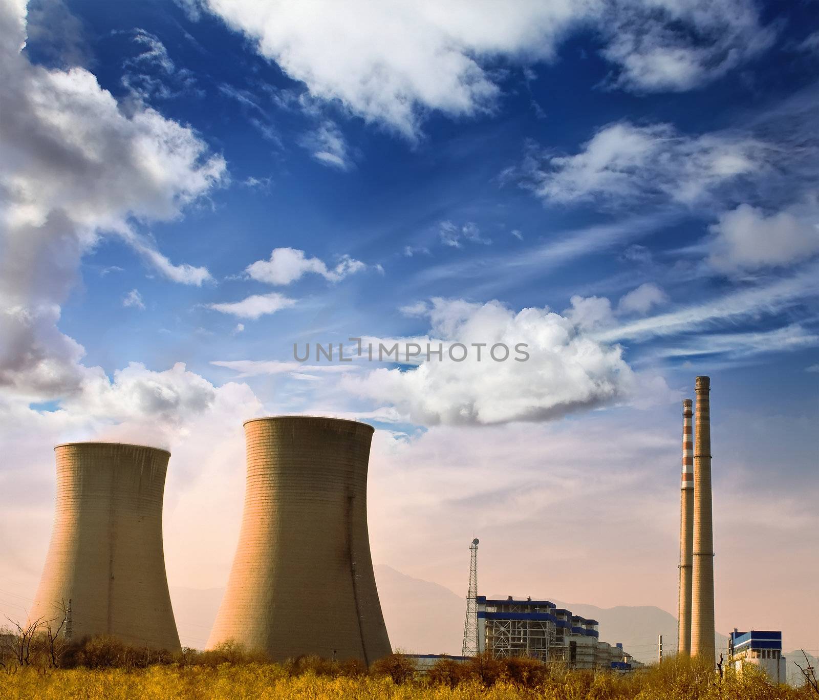 Landscape photo of industrial factory with power chimneys in blue sky in rurial area