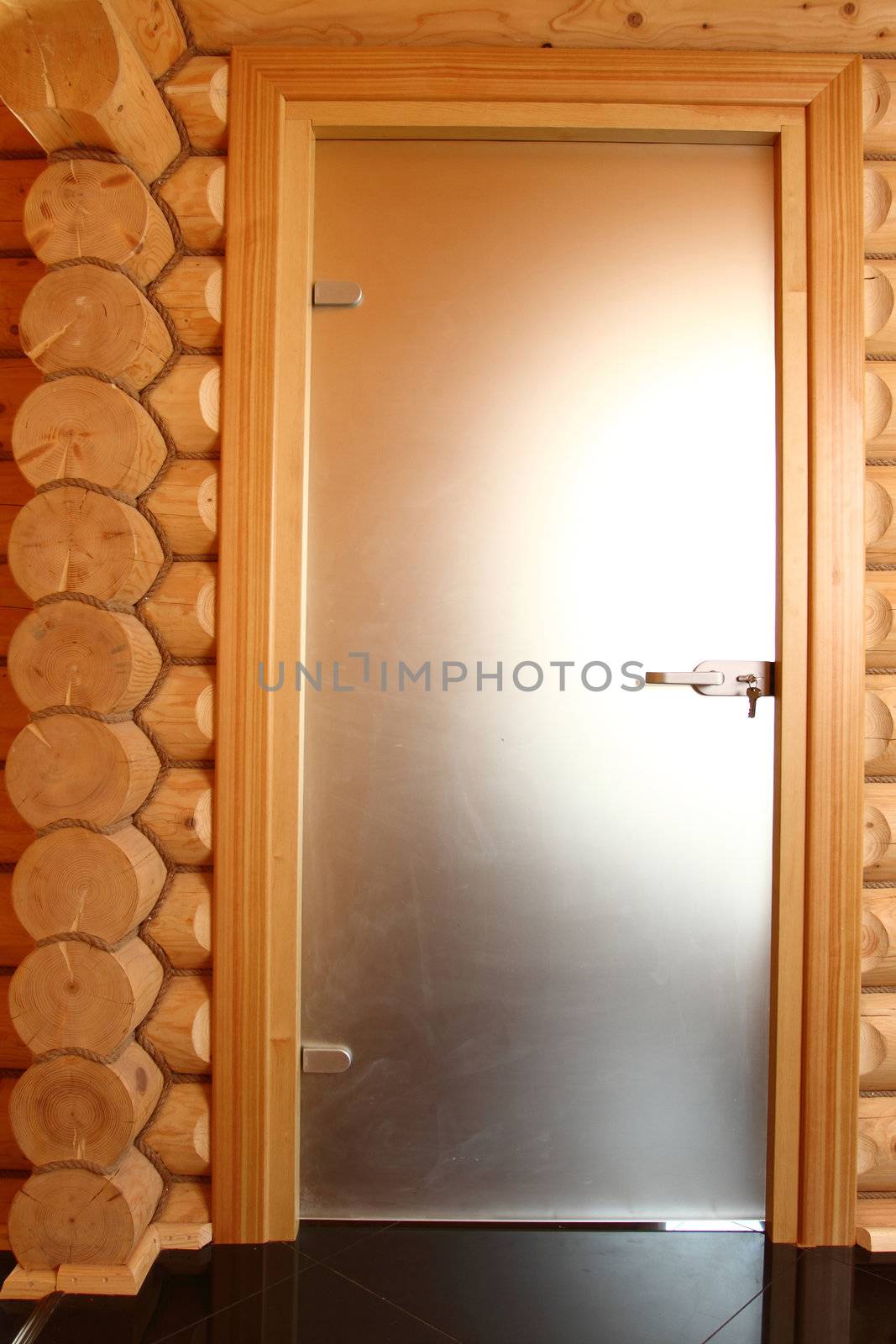 Fragment of a wall of the wooden house with a door from the calibrated bar