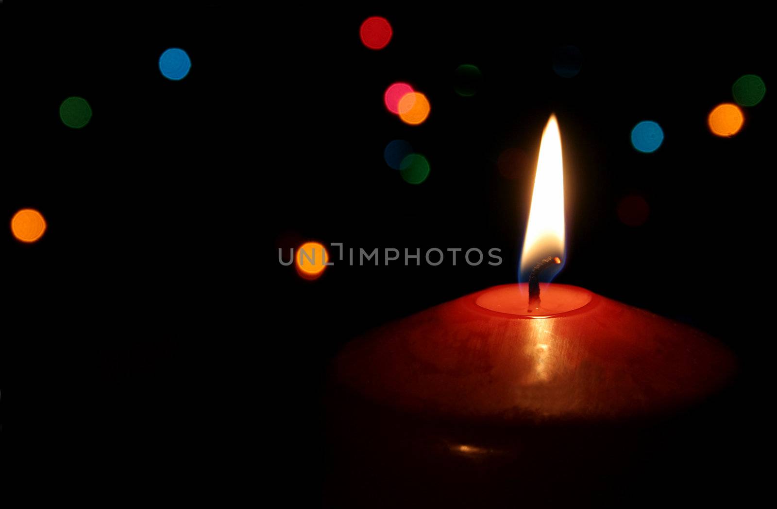 A single lit red Christmas candle.