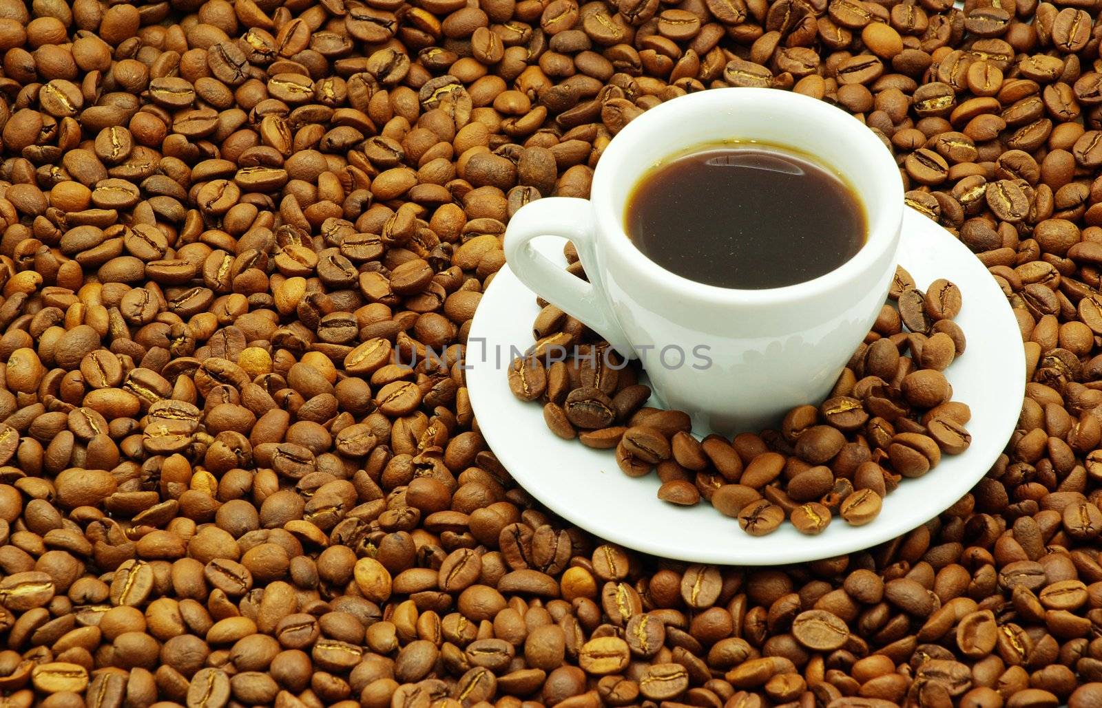 white cup with coffee costing on a coffee grain