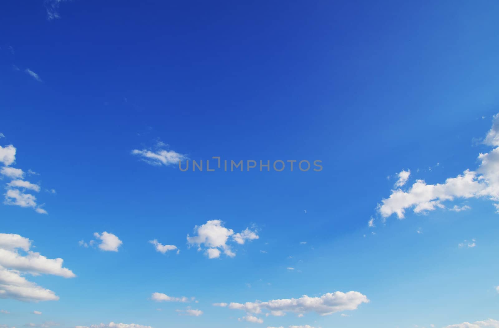 Blue sky background with tiny clouds