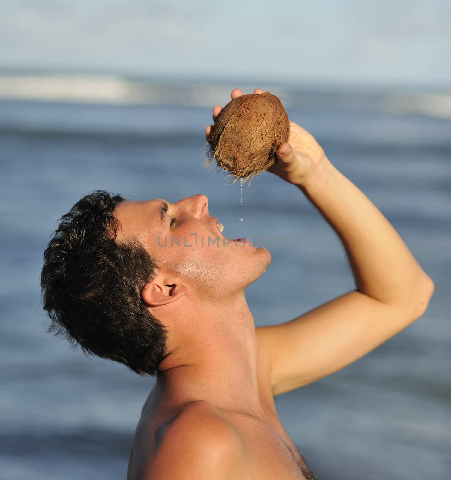 Man refreshing on the beach with a coconut