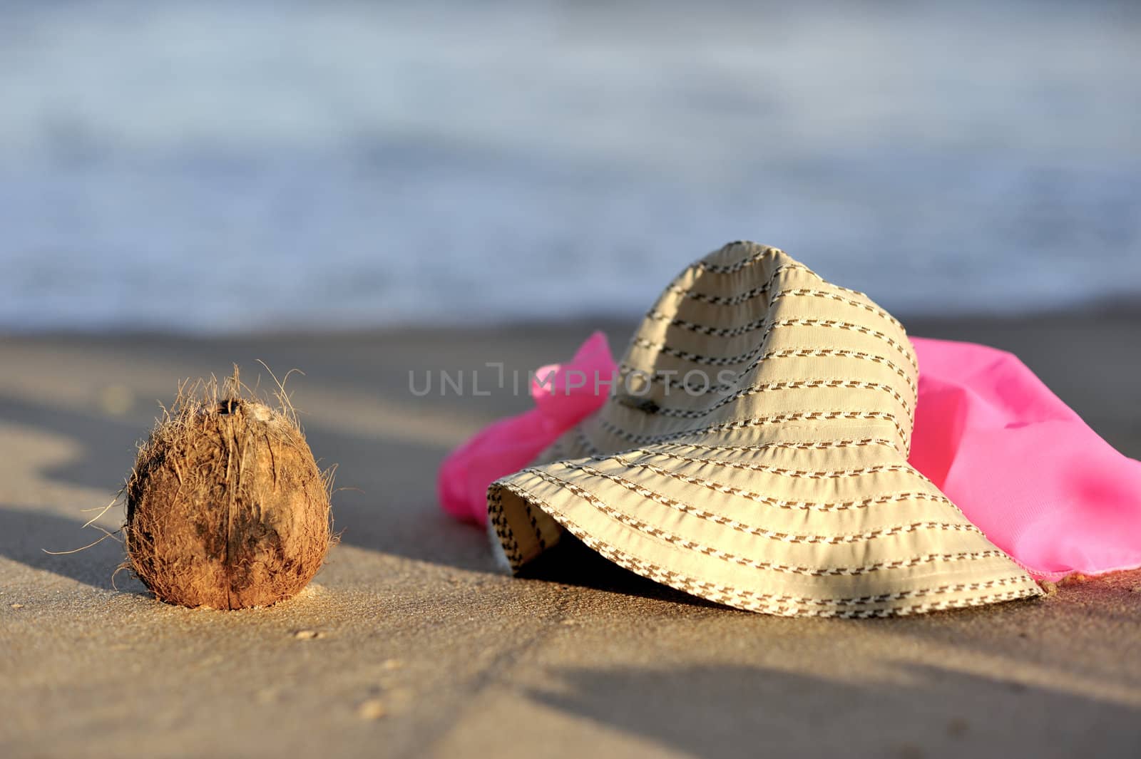 Hat and coconut on the beach