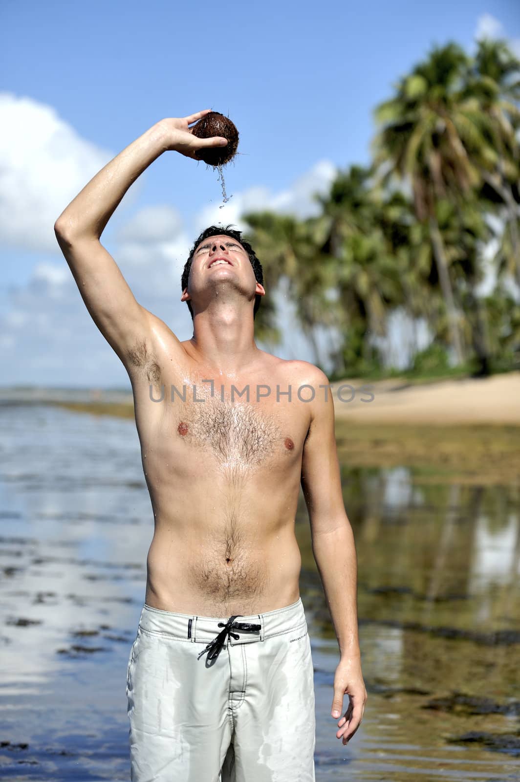 Man refreshing on the beach with a coconut