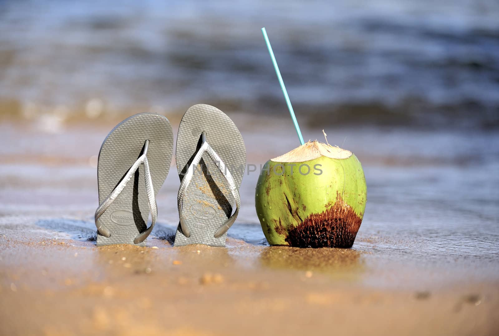 Thongs and coconut on the beach in Brazil.