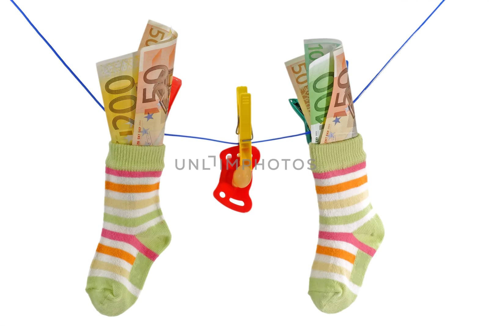 Baby socks with pacifier and euro banknotes on aclothline. Isolated on white background.