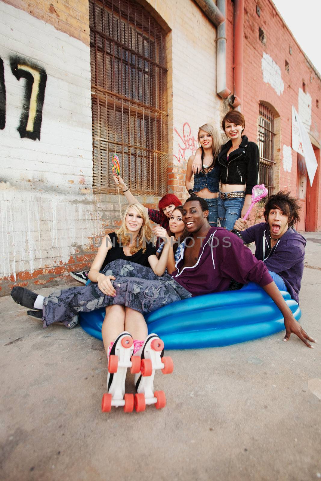 Fun loving group of teen punks sit in an inflatable pool by Creatista