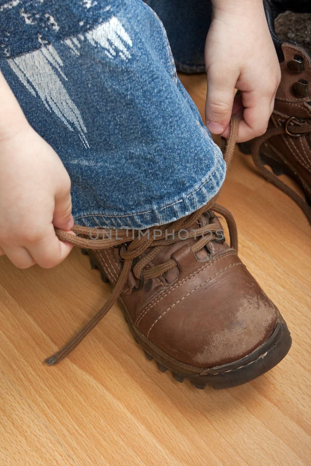 Little child boy hand tying foot sport shoe lace