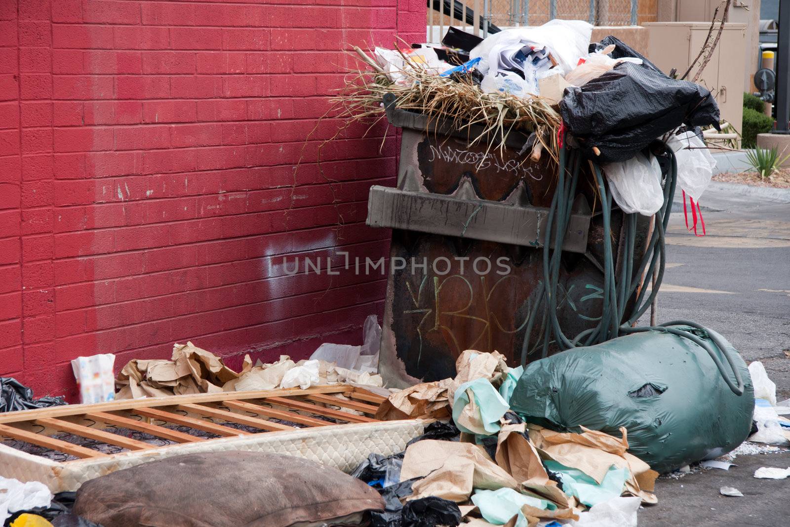 overfilled trash dumpster in ghetto neigborhood