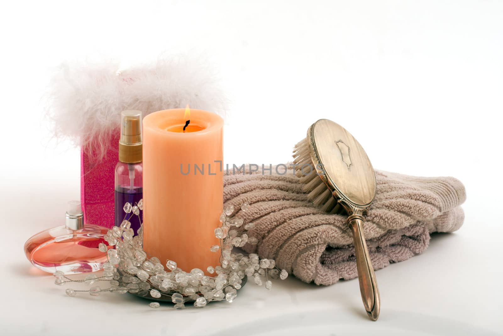 Candle perfume lotion towel hair brush in spa on isolated white