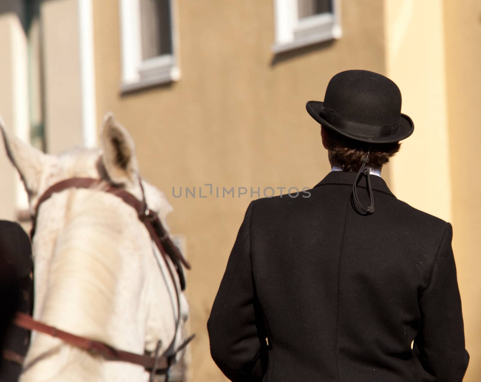 Man with kentucky or german top hat riding helmet on sunny day