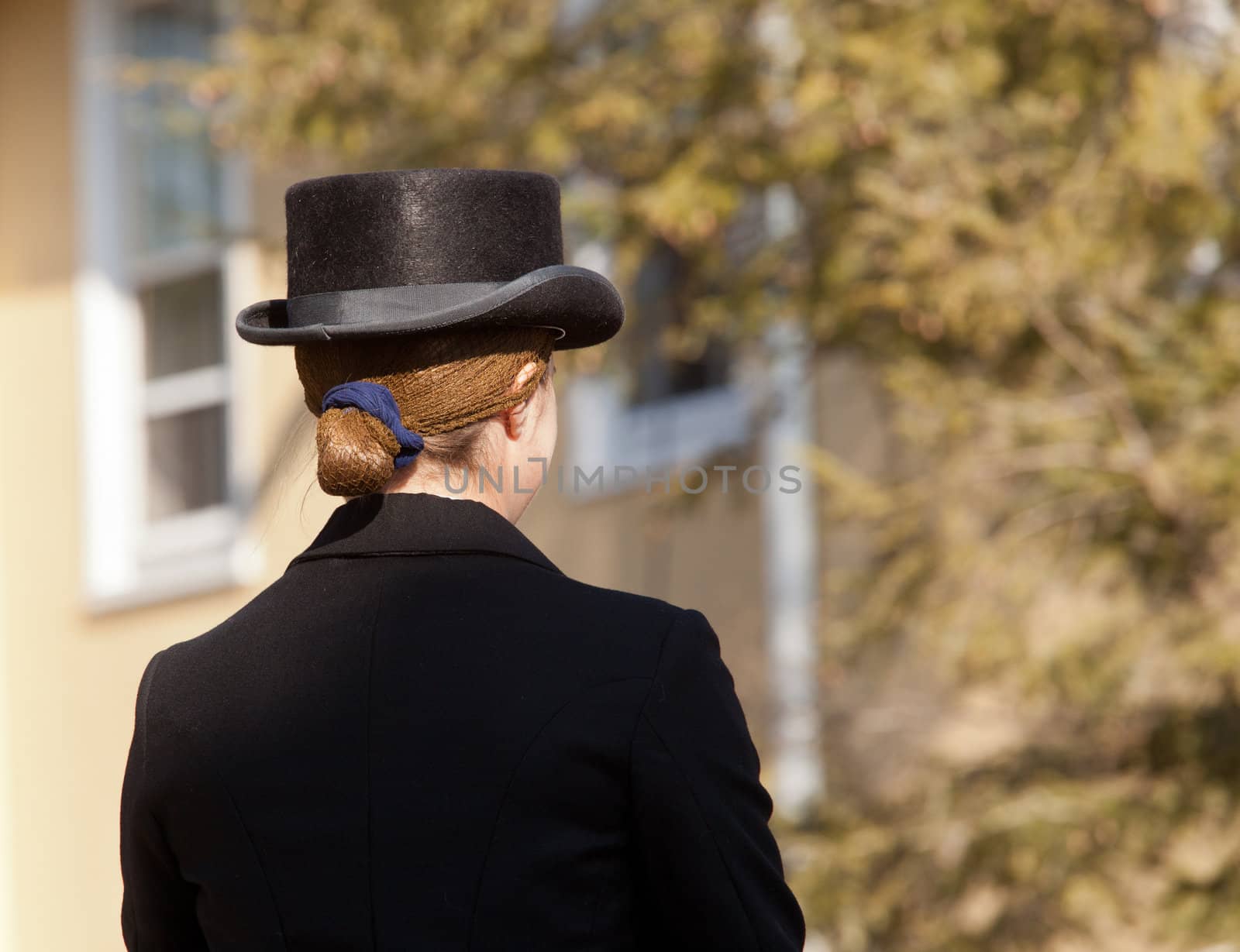 Lady with kentucky or german top hat riding helmet on sunny day