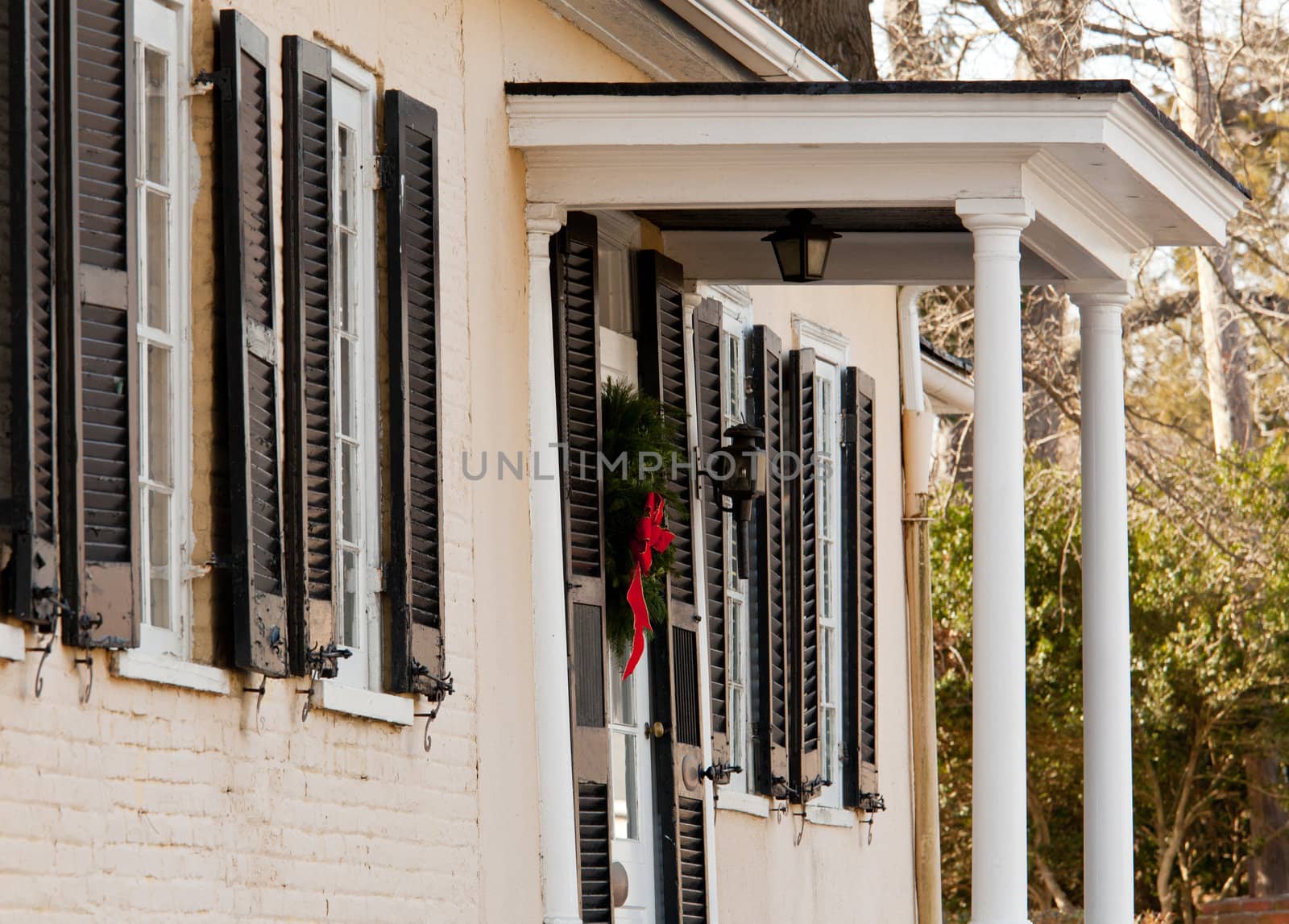 Old brick colonial house decorated for Christmas with wreath on door