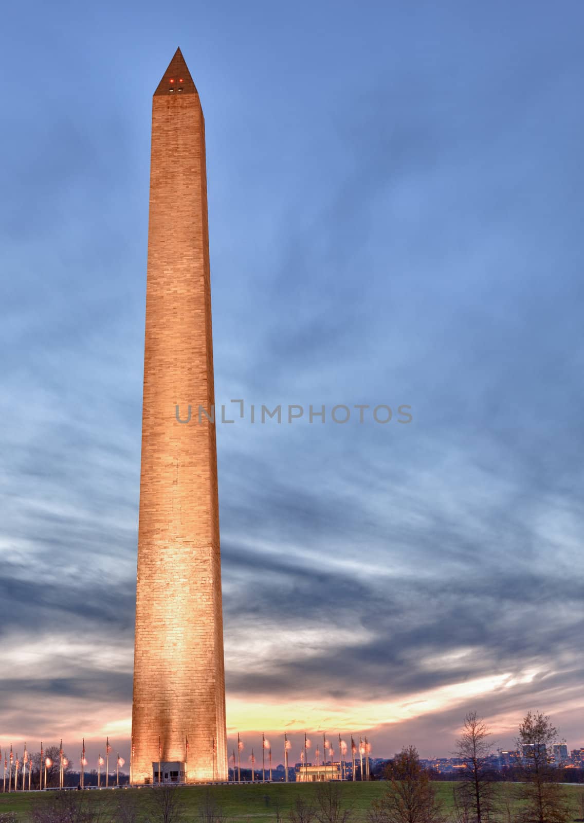 Washington Monument in DC at dusk as the sun is setting and tower is illuminated