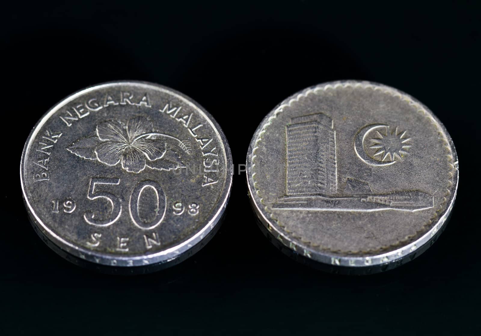 Malaysian currency coins on a black mirror surface