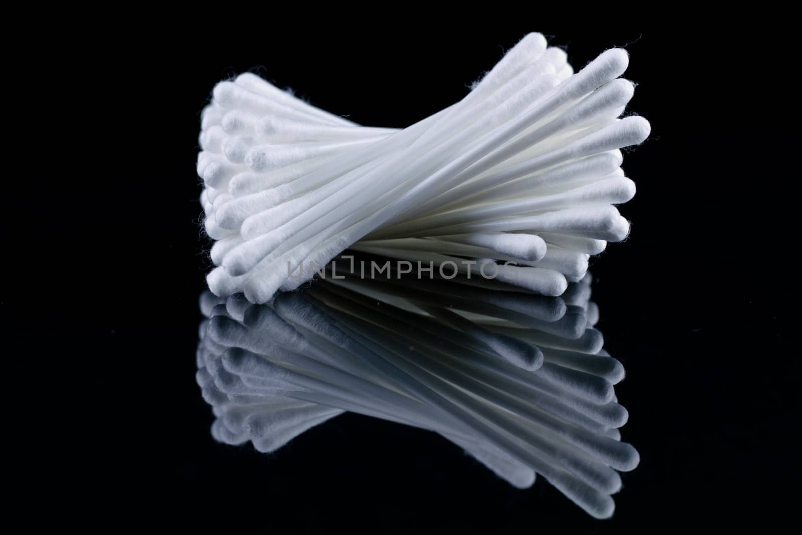 cotton wool buds on black mirror with mirror image and black background