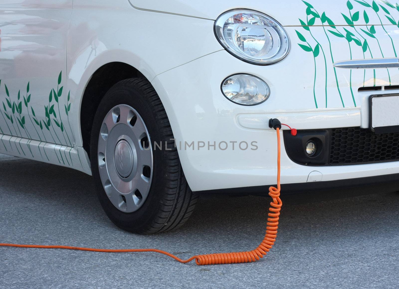 Electric car recharging its batteries with cable plugged in.