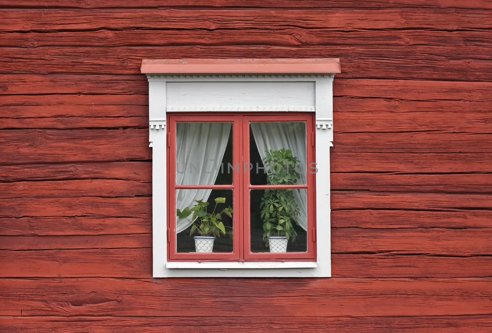 Cute window on red swedish house wall