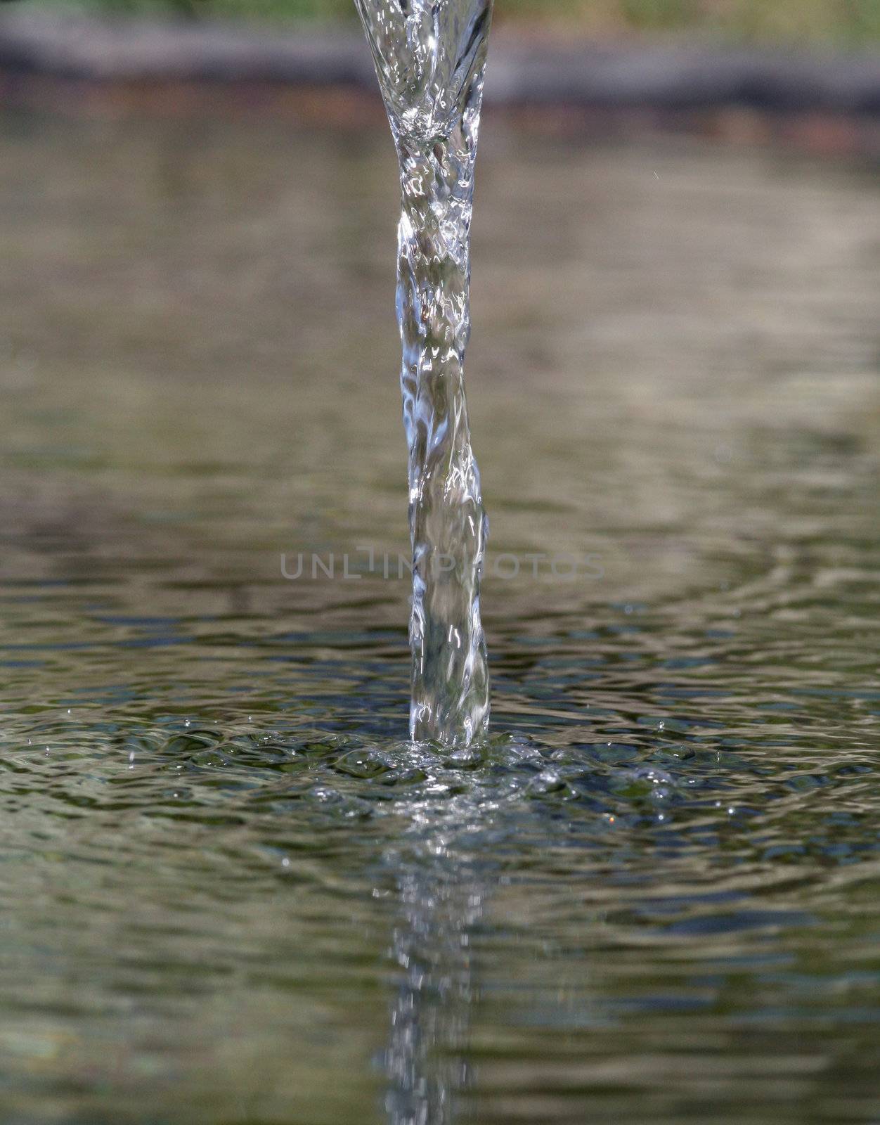 Fresh water ripple pouring down into water surface.