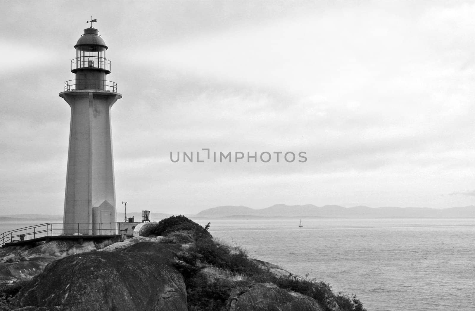 Black and White Photo of Ocean shore with Classic Lighthouse