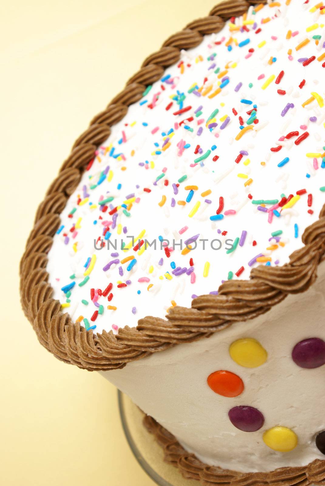 A decorated cake rests on a yellow background to celebrate an occasion.